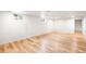 The basement is well-lit, featuring hardwood floors and white walls; windows allow for natural light at 3054 S Raleigh St, Denver, CO 80236