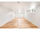 Spacious basement area with hardwood floors, white walls, and well-lit with ceiling and window lighting at 3054 S Raleigh St, Denver, CO 80236