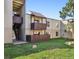 Building exterior features a grassy lawn with a balcony, a covered deck and stairs at 9995 E Harvard Ave # 221, Denver, CO 80231