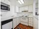 Galley kitchen featuring white cabinetry, countertops, and appliances at 9995 E Harvard Ave # 221, Denver, CO 80231