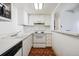 Galley kitchen featuring white cabinetry, countertops, and appliances at 9995 E Harvard Ave # 221, Denver, CO 80231