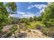 Lush backyard with beautiful landscaping and mature trees creating a private oasis at 11462 W Tennessee Pl, Lakewood, CO 80226