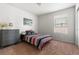 Cozy bedroom with a striped bedspread, dresser, and ample natural light from the window, creating a relaxing space at 9535 Dexter Ln, Thornton, CO 80229