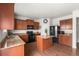 Kitchen showcases warm wood cabinetry, granite countertops, modern appliances, and hardwood flooring at 9535 Dexter Ln, Thornton, CO 80229