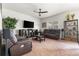 Comfortable living room features leather furniture, a ceiling fan, media center, and plush carpeting at 9535 Dexter Ln, Thornton, CO 80229