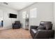 Comfortable living room featuring plush armchairs, a wall-mounted TV, and natural light from two windows at 9535 Dexter Ln, Thornton, CO 80229