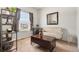 Bright sitting area featuring a window, modern shelving, stylish furniture, and neutral carpeting at 9535 Dexter Ln, Thornton, CO 80229