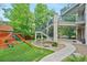The backyard has a playset, stone steps and walkway, and stairs leading to an upper deck at 11465 W Atlantic Ave, Lakewood, CO 80227