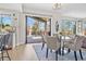 Bright dining area with modern chandelier, deck access and views of mature trees and surrounding neighborhood at 11465 W Atlantic Ave, Lakewood, CO 80227