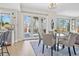 Bright dining area with modern chandelier, deck access and views of mature trees and surrounding neighborhood at 11465 W Atlantic Ave, Lakewood, CO 80227