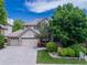 Charming two-story home with a well-manicured front lawn, mature landscaping, and an attached three-car garage at 11465 W Atlantic Ave, Lakewood, CO 80227