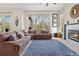 Spacious living room featuring a fireplace, large sectional sofa, and views of the outdoors from expansive windows at 11465 W Atlantic Ave, Lakewood, CO 80227