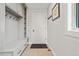 Neat mudroom with built-in bench, coat hooks, and storage cabinets for organization at 11465 W Atlantic Ave, Lakewood, CO 80227