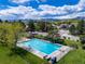A community pool is surrounded by lush green grass, trees, and fenced in for safety, nestled in the Colorado mountains at 11465 W Atlantic Ave, Lakewood, CO 80227