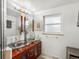 Bathroom featuring double vessel sinks, modern fixtures, and ample natural light from the large window at 5845 W Portland Dr, Littleton, CO 80128