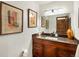 Bathroom featuring a granite countertop vanity with a warm wooden cabinet and decorative framed abstract art at 5845 W Portland Dr, Littleton, CO 80128