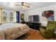 Bedroom with hardwood floors, large windows, a ceiling fan, and a comfortable bed, providing a relaxing ambiance at 5845 W Portland Dr, Littleton, CO 80128