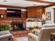 Cozy living room with a brick fireplace, hardwood floors and wood beams at 5845 W Portland Dr, Littleton, CO 80128