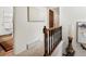 Upstairs hallway featuring carpeted flooring, wooden railings, and light walls with decorative art at 5845 W Portland Dr, Littleton, CO 80128