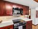 Bright kitchen features stainless steel appliances, custom cabinets and light countertops at 5845 W Portland Dr, Littleton, CO 80128