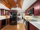 Modern kitchen with wooden ceiling, stainless appliances, and dark wood cabinets at 5845 W Portland Dr, Littleton, CO 80128