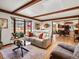 Living room with hardwood floors, wood beams, and view of the dining area at 5845 W Portland Dr, Littleton, CO 80128