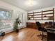 Home office with a built-in wood bookcase, hardwood floors, and natural light from the window at 5845 W Portland Dr, Littleton, CO 80128