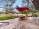 Enjoy outdoor living with a stone patio, furnished with an umbrella and chairs at 5845 W Portland Dr, Littleton, CO 80128