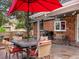 Outdoor living space featuring a brick facade, an umbrella, and outdoor seating at 5845 W Portland Dr, Littleton, CO 80128