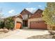 Beautiful home showcasing a three-car garage, stone accents, and a well-manicured lawn at 15711 Josephine Cir, Brighton, CO 80602