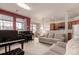 Open-concept living room with pianos, views of the kitchen and dining area, with large windows at 3577 Molly Cir, Broomfield, CO 80023