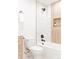 Modern bathroom featuring a sleek white tub with a shower and stylish vanity at 4395 Newland St, Wheat Ridge, CO 80033