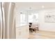 Bright dining area with modern stainless steel refrigerator, dining table, and natural light from large windows at 4395 Newland St, Wheat Ridge, CO 80033