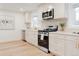 Modern kitchen featuring stainless steel appliances, white cabinets, a modern stove, and bright countertops at 4395 Newland St, Wheat Ridge, CO 80033