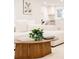 Stylish living room with a cozy white sofa, wooden coffee table with a plant, and a view of the modern kitchen at 4395 Newland St, Wheat Ridge, CO 80033