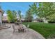 Inviting backyard featuring a stone patio with a fire pit and seating area surrounded by lush greenery and a well-maintained lawn at 12430 S Downy Creek Ct, Parker, CO 80134