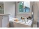 Bright bathroom featuring a garden bathtub, window, tile surround, and a glass-enclosed shower at 12430 S Downy Creek Ct, Parker, CO 80134