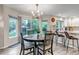 Cozy dining area with a round table, modern chandelier, and views into the backyard and kitchen at 12430 S Downy Creek Ct, Parker, CO 80134