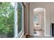 Hallway leading to the main bathroom, featuring a luxurious soaking tub and shower with bright light at 12430 S Downy Creek Ct, Parker, CO 80134