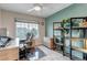 Well-lit home office featuring a neutral color scheme, modern desk, and organized storage shelving at 12430 S Downy Creek Ct, Parker, CO 80134