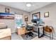 Bright home office space with a large window, desk setup, comfortable seating, and modern décor at 12430 S Downy Creek Ct, Parker, CO 80134