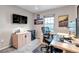 Modern home office with a work desk, monitor, mini-fridge, natural lighting, and decor at 12430 S Downy Creek Ct, Parker, CO 80134