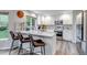 Bright kitchen featuring white cabinetry, modern stainless steel appliances, a breakfast bar, and quartz countertops at 12430 S Downy Creek Ct, Parker, CO 80134