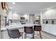 Modern kitchen with white cabinets, stainless steel appliances, and a large island with bar stool seating at 12430 S Downy Creek Ct, Parker, CO 80134