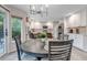 Bright eat-in kitchen boasts white cabinetry, stainless steel appliances, modern lighting, and a charming round dining table at 12430 S Downy Creek Ct, Parker, CO 80134