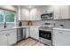 Well-equipped kitchen featuring stainless steel appliances, white cabinetry, and sleek countertops at 12430 S Downy Creek Ct, Parker, CO 80134
