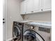 Convenient laundry room with modern washer and dryer, ample counter space, and storage cabinets for efficient organization at 12430 S Downy Creek Ct, Parker, CO 80134