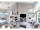 Spacious living room with soaring ceilings, a cozy fireplace, large windows, and stylish neutral decor at 12430 S Downy Creek Ct, Parker, CO 80134