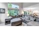 Bright living room with a large sectional sofa, big windows, and access to the dining and backyard areas at 12430 S Downy Creek Ct, Parker, CO 80134