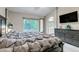 Comfortable main bedroom with king bed, dresser, TV, and access to ensuite bathroom and scenic outdoor views at 12430 S Downy Creek Ct, Parker, CO 80134